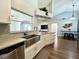 Bright kitchen featuring a stainless steel sink, modern faucet, white cabinets, and an island with pendant lights at 1813 Landside Dr, Valrico, FL 33594