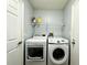Functional laundry room with white appliances and practical shelving for storage and organization at 1813 Landside Dr, Valrico, FL 33594