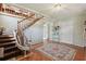 Welcoming foyer with staircase featuring a chair lift and a decorative rug on the tiled floor at 1842 Bayou Grande Ne Blvd, St Petersburg, FL 33703