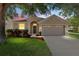 Charming single-story home boasts a well-manicured lawn, two-car garage, and neutral stucco exterior at 18816 Narimore Dr, Land O Lakes, FL 34638