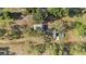 Aerial view of the property, featuring a quaint pool, home, and ample yard space with mature trees at 18838 Huckavalle Rd, Odessa, FL 33556