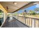 Inviting covered balcony with ample space and rustic railings, perfect for enjoying the tranquil outdoor setting at 18838 Huckavalle Rd, Odessa, FL 33556