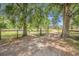 Scenic driveway leading to a property surrounded by lush trees and fencing at 18838 Huckavalle Rd, Odessa, FL 33556