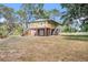 Charming two-story home with a lovely deck and a brick foundation, surrounded by lush trees and a sprawling yard at 18838 Huckavalle Rd, Odessa, FL 33556