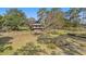 Two-story exterior featuring a yellow facade, brick foundation, and a charming balcony, surrounded by beautiful trees at 18838 Huckavalle Rd, Odessa, FL 33556