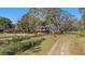 Quaint two-story home boasting a charming yellow facade and balcony, framed by mature trees and greenery at 18838 Huckavalle Rd, Odessa, FL 33556