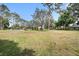 Large grassy yard featuring an above-ground pool, a covered structure, and plenty of space for recreation and relaxation at 18838 Huckavalle Rd, Odessa, FL 33556