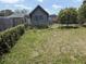 Large overgrown backyard with chain link and wooden fences, plus a view of other houses at 1905 Meridel Ave, Tampa, FL 33612