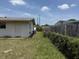 Home's backyard with sparse grass, a rear entrance, partial fencing and an AC unit at 1905 Meridel Ave, Tampa, FL 33612
