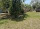 Backyard showing some trees, grass and partial fencing at 1905 Meridel Ave, Tampa, FL 33612