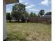 A view of the backyard with a mix of vegetation and a wooden fence line at 1905 Meridel Ave, Tampa, FL 33612
