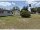 View of the backyard with overgrown lawn between houses at 1905 Meridel Ave, Tampa, FL 33612