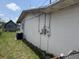 Side exterior of home with white concrete walls, air conditioning unit, and utility access at 1905 Meridel Ave, Tampa, FL 33612