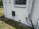 Exterior wall with utility connections, a water meter access, and an electrical junction box at 1905 Meridel Ave, Tampa, FL 33612