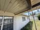 Shows the exterior wall and part of the home's facade near an overgrown side yard at 1905 Meridel Ave, Tampa, FL 33612