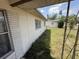 Shows the exterior wall and part of the home's facade near an overgrown side yard at 1905 Meridel Ave, Tampa, FL 33612