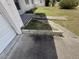 Shows the unkempt yard and deteriorating deck adjacent to the home's driveway at 1905 Meridel Ave, Tampa, FL 33612