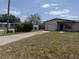 View of home from across the driveway with blue skies and scattered clouds overhead at 1905 Meridel Ave, Tampa, FL 33612
