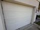 White garage door with paneling with address numbers on a white house at 1905 Meridel Ave, Tampa, FL 33612