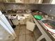 View of cluttered kitchen needing renovation with dated cabinets and a stainless steel sink at 1905 Meridel Ave, Tampa, FL 33612