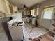View of cluttered kitchen needing renovation with white cabinets and appliances at 1905 Meridel Ave, Tampa, FL 33612