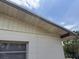 Close up view of roofline and the exterior wall with window, showing beige and brown coloring at 1905 Meridel Ave, Tampa, FL 33612