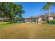 Expansive backyard featuring lush grass, mature trees, and a screened lanai, perfect for outdoor living at 2007 Acadia Greens Dr # 0, Sun City Center, FL 33573