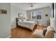 Cozy bedroom featuring wood floors, a ceiling fan, and bright natural light from a large window at 2007 Acadia Greens Dr # 0, Sun City Center, FL 33573