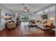 Bright living room featuring hardwood floors, ceiling fan, and sliding glass doors to outdoor space at 2007 Acadia Greens Dr # 0, Sun City Center, FL 33573