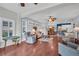Open-concept living room with hardwood floors and natural light, seamlessly connecting to dining and kitchen areas at 2007 Acadia Greens Dr # 0, Sun City Center, FL 33573