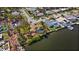 Aerial view of a waterfront home with a pool, boat dock, and lush tropical landscaping on the canal at 2142 Ibis, Clearwater, FL 33764