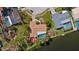 Aerial view of canal-front home with mature trees, pool, and private boat dock on a sunny day at 2142 Ibis, Clearwater, FL 33764