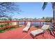 Waterfront home with a bright red wooden deck and two lounge chairs overlooking the canal at 2142 Ibis, Clearwater, FL 33764