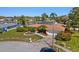 Well-maintained yellow single-story home featuring mature landscaping, a two-car garage, and a canal view at 2142 Ibis, Clearwater, FL 33764