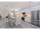 Modern kitchen boasts stainless steel appliances, center island with seating, and light wood-look flooring at 2150 43Rd N Ter, St Petersburg, FL 33714