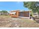 Exterior view of the back of the home showing a porch and spacious yard at 3065 Merrill Ave, Clearwater, FL 33759