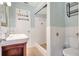 Bright bathroom featuring white tiled walls, a walk-in shower, and a classic vanity sink at 3065 Merrill Ave, Clearwater, FL 33759