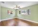 This bedroom features laminate wood floors, a ceiling fan, and plenty of natural light from the windows at 3065 Merrill Ave, Clearwater, FL 33759