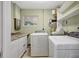 Bright laundry room featuring modern appliances, white cabinets and neutral tile floors at 3065 Merrill Ave, Clearwater, FL 33759