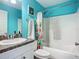 Bathroom with blue walls, vanity with sink and faucet, toilet, and tub with shower at 3212 55Th E St, Palmetto, FL 34221