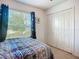 Bedroom features window with blinds, view to exterior, and closet with folding doors at 3212 55Th E St, Palmetto, FL 34221