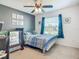 Bedroom featuring a crib and bed with a ceiling fan and a view to the exterior at 3212 55Th E St, Palmetto, FL 34221
