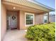 A welcoming front entrance features a gray door with a wreath and lush green landscaping at 3212 55Th E St, Palmetto, FL 34221