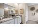Bright bathroom features double vanity with granite countertops, decorative accents, and neutral wall paint at 32450 Osprey Peak Way, San Antonio, FL 33576
