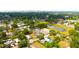 An aerial view showcasing homes amidst lush greenery, near a pond, with a distant cityscape at 3306 E Chelsea St, Tampa, FL 33610