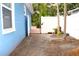 Side yard with a brick walkway, exterior home view, and white fencing at 3306 E Chelsea St, Tampa, FL 33610