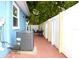 Backyard with a brick patio, an air conditioning unit, and white fencing at 3306 E Chelsea St, Tampa, FL 33610