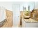 Well-lit bathroom featuring white cabinets, a stone sink, and decorative tile accents at 3306 E Chelsea St, Tampa, FL 33610