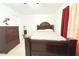 Simple bedroom featuring a dark wood bed frame, matching dresser, and a calming atmosphere at 3306 E Chelsea St, Tampa, FL 33610