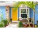 Inviting entryway with a striking yellow door, stone accents, and a cozy seating area at 3306 E Chelsea St, Tampa, FL 33610